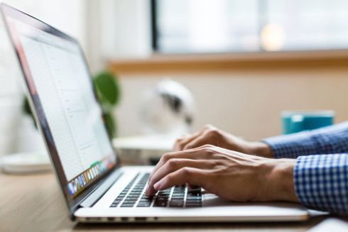 Mann tippend auf Laptop